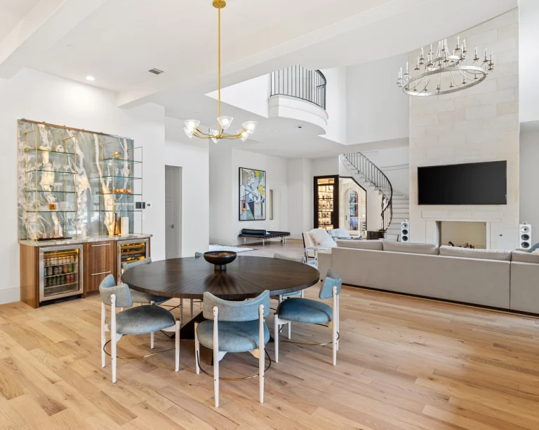 Open-concept living room with dining area, wet bar, spiral staircase, fireplace, and large TV