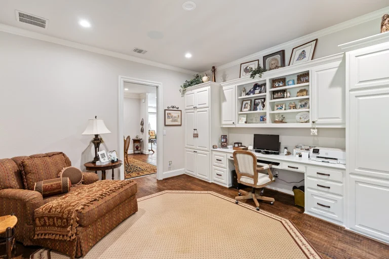 Cozy home office with white built-in desk, shelves, computer, printer, and comfortable chaise lounge